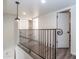 Second-floor hallway with iron railing, a pendant light, and white doors at 1327 W Glendale Ave, Phoenix, AZ 85021