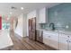 Charming modern kitchen featuring stainless steel appliances, white cabinets, and light blue tile backsplash at 1327 W Glendale Ave, Phoenix, AZ 85021