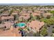 Community aerial with a resort-style pool, palm trees, and manicured landscaping set among residential buildings at 14250 W Wigwam Blvd # 1022, Litchfield Park, AZ 85340