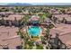 Aerial view of resort-style community pool with jacuzzi, palm trees and community seating areas at 14250 W Wigwam Blvd # 1022, Litchfield Park, AZ 85340