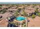 Aerial shot of a resort-style pool, palm trees, lounge chairs, and well-maintained community buildings at 14250 W Wigwam Blvd # 1022, Litchfield Park, AZ 85340