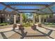 Stunning courtyard featuring an elaborate pergola, manicured landscaping, and stately white columns at 14250 W Wigwam Blvd # 1022, Litchfield Park, AZ 85340