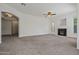 Open living room featuring a fireplace, neutral carpet, and natural light from multiple windows at 14250 W Wigwam Blvd # 1022, Litchfield Park, AZ 85340