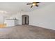 Spacious living room featuring neutral carpet and white walls, with a view into the kitchen at 14250 W Wigwam Blvd # 1022, Litchfield Park, AZ 85340