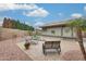 Inviting backyard patio with chaise lounges, mature trees, and privacy fencing at 14458 W Powderhorn Dr, Surprise, AZ 85374