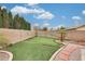 Landscaped backyard with artificial turf, a putting green, and privacy wall at 14458 W Powderhorn Dr, Surprise, AZ 85374