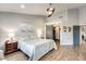 Bright bedroom featuring light grey walls, ceiling fan, wood floors and closet with stylish barn door at 14458 W Powderhorn Dr, Surprise, AZ 85374