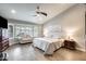 Spacious main bedroom boasts neutral walls, a ceiling fan, and a bay window offering lots of natural light at 14458 W Powderhorn Dr, Surprise, AZ 85374