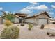 Well-maintained home exterior showcasing stone accents, desert landscaping, and a two-car garage at 14458 W Powderhorn Dr, Surprise, AZ 85374