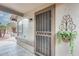 Inviting front porch featuring a secure screen door and a decorative hanging plant at 14458 W Powderhorn Dr, Surprise, AZ 85374