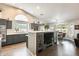 Modern kitchen featuring gray cabinets, stainless steel appliances, a breakfast bar, and a cozy eat-in area at 14458 W Powderhorn Dr, Surprise, AZ 85374