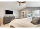 This main bedroom features a calming color palette, ceiling fan, dresser, and patio access at 14458 W Powderhorn Dr, Surprise, AZ 85374