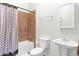 Neutral bathroom with white fixtures, including a toilet, sink, and shower-tub combo with patterned curtain at 1454 E Flower St, Phoenix, AZ 85014