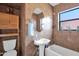 Well-lit bathroom features a pedestal sink, tiled walls, and a shower-tub combo at 1454 E Flower St, Phoenix, AZ 85014