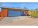 Home exterior featuring a blue two-car garage and well-kept driveway at 1454 E Flower St, Phoenix, AZ 85014