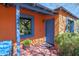 Inviting front entrance showcasing blue door, vibrant orange walls, and desert landscaping at 1454 E Flower St, Phoenix, AZ 85014