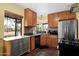 Cozy kitchen featuring warm wood cabinets, stainless steel appliances, and terracotta tile flooring at 1454 E Flower St, Phoenix, AZ 85014