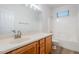 Bright bathroom featuring single sink vanity with wood cabinets and a shower-tub combo with tile surround at 15853 N 74Th Ave, Peoria, AZ 85382