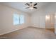 This bedroom features neutral carpeting, a ceiling fan, and bright natural light from a window at 15853 N 74Th Ave, Peoria, AZ 85382