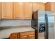 Close-up of stainless steel refrigerator and light-colored wood cabinets at 15853 N 74Th Ave, Peoria, AZ 85382