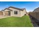 A view of the neutral colored home and backyard with artificial turf at 1627 E Walter Dr, Casa Grande, AZ 85122