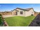 A view of the neutral colored home and backyard with artificial turf at 1627 E Walter Dr, Casa Grande, AZ 85122