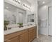 Well-lit bathroom with double vanity, sleek mirrors, and a glass-enclosed shower for a modern feel at 1627 E Walter Dr, Casa Grande, AZ 85122