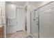 Bright bathroom featuring a glass-enclosed shower, towel rack, and neutral tile flooring at 1627 E Walter Dr, Casa Grande, AZ 85122