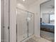 Modern bathroom with a glass-enclosed shower, and a view into the primary bedroom at 1627 E Walter Dr, Casa Grande, AZ 85122