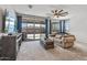 Spacious living room with backyard view, sliding glass doors with curtains, and modern ceiling fan at 1627 E Walter Dr, Casa Grande, AZ 85122