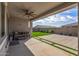 A covered patio features a ceiling fan, a grill and artificial grass accents in the concrete at 1627 E Walter Dr, Casa Grande, AZ 85122