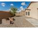 View of backyard with brick firepit and lush green tree at 17125 W Saguaro Ln, Surprise, AZ 85388