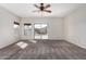 Bright main bedroom with carpet, windows, and sliding glass door with access to the backyard at 17125 W Saguaro Ln, Surprise, AZ 85388