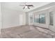 Spacious main bedroom with neutral walls, carpet flooring, ceiling fan, and large windows for ample natural light at 17125 W Saguaro Ln, Surprise, AZ 85388