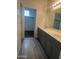 Bathroom featuring a double sink vanity, gray cabinets, and wood-look tile flooring leading to a walk-in closet at 1717 W Pollack St, Phoenix, AZ 85041