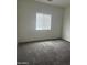 An empty bedroom with gray carpet, a window for natural light, and a neutral color scheme awaiting personalization at 1717 W Pollack St, Phoenix, AZ 85041