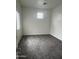 An empty bedroom with gray carpet, a window for natural light, and a neutral color scheme awaiting personalization at 1717 W Pollack St, Phoenix, AZ 85041