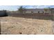 A spacious, empty backyard framed by a block wall and a white iron fence, offering a clean slate for landscaping at 17296 W Desert Sage Dr, Goodyear, AZ 85338