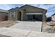 Single-story home showcasing a neutral color palette, an open two-car garage, and a freshly poured concrete driveway at 17296 W Desert Sage Dr, Goodyear, AZ 85338