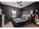 Modern bedroom featuring dark accent wall, carpet and ample lighting at 18316 N Soft Wind Dr, Maricopa, AZ 85138