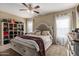 Bright bedroom featuring a neutral color palette, an upholstered headboard, and a built-in storage bench at the foot of the bed at 18316 N Soft Wind Dr, Maricopa, AZ 85138