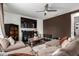 Inviting living room featuring a plush sectional sofa, media center, and ceiling fan at 18316 N Soft Wind Dr, Maricopa, AZ 85138