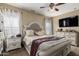 Cozy main bedroom with large bed, bedside tables, and mounted TV at 18316 N Soft Wind Dr, Maricopa, AZ 85138