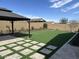 Backyard featuring a gazebo, artificial turf, and a stone paver walkway at 19864 W San Juan Ave, Litchfield Park, AZ 85340