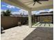 Inviting backyard patio area with travertine pavers, a gazebo, artificial turf, and desert landscaping at 19864 W San Juan Ave, Litchfield Park, AZ 85340