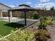 Lush backyard showcasing a gazebo, artificial turf, desert landscaping, and decorative bird figures at 19864 W San Juan Ave, Litchfield Park, AZ 85340