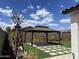 Beautiful backyard featuring an outdoor gazebo on artificial turf, a windmill decoration, and flower beds at 19864 W San Juan Ave, Litchfield Park, AZ 85340