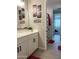 Bright bathroom featuring a white vanity with dual sinks, neutral tile flooring, and decorative wall art at 19864 W San Juan Ave, Litchfield Park, AZ 85340