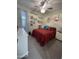 Cozy bedroom with red comforter, plush carpet, ceiling fan, and charming decorative shelves at 19864 W San Juan Ave, Litchfield Park, AZ 85340