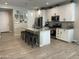 Well-lit kitchen features a granite island with seating, stainless steel appliances, and white cabinets at 19864 W San Juan Ave, Litchfield Park, AZ 85340